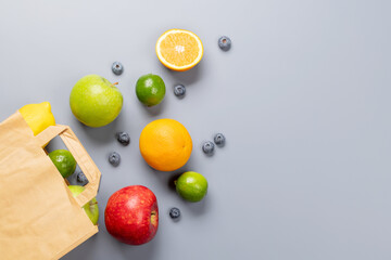 Shopping paper bag full of healthy food on grey