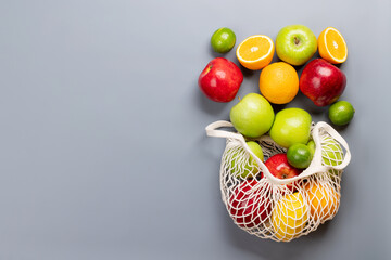 Shopping mesh bag full of healthy food on grey