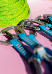 green rope and climbing and mountaineering equipment lies on a colored background. background image of rope and equipment for active sports.