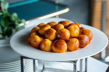 Mini Babà napoletani bagnati con il rum serviti come dolce ad un buffet di un evento elegante