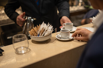 Cliente di un bar napoletano mentre viene servito al banco con due caffè espressi in tazzine di ceramica 
