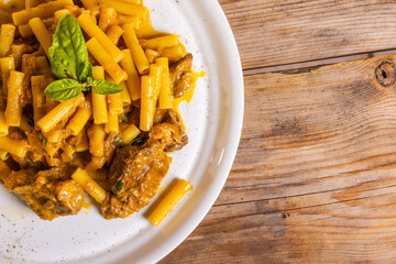 Piatto di pasta con sugo di genovese napoletana con carne e cipolle guarnito con formaggio grattugiato e basilico fresco servito in un ristorante napoletano