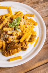 Piatto di pasta con sugo di genovese napoletana con carne e cipolle guarnito con formaggio...