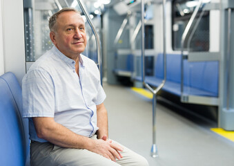 Fototapeta premium Middle aged man sitting in subway car