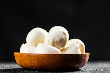 Mozzarella cheese in a wooden plate on the table. 