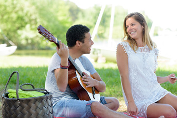 young couple in love in park with a guitar