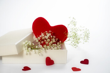 Red heart shape from felt in a white gift box with gypsophila or baby breath flowers, love symbol...