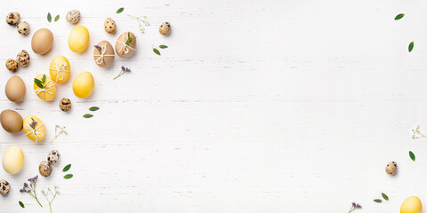 Festive Easter background. Easter eggs with flowers on a white table. Flat lay, place for text.