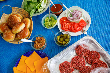 Fastfood, burger party concept. Various delicious burgers set with french fries and sauces on bright blue background flatlay top view copy space
