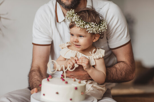 Cute baby girl sitting on dad lap's at home