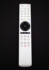 White remote control for TV on black background
