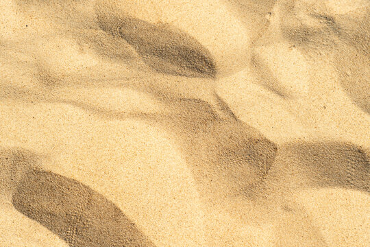 Close-up of yellow sand on the beach. Small grains of sand on a clean beach. Toned photo with low depth of field.
