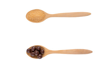 Brown sugar on wooden spoon and chocolate balls on wooden spoon on a transparent background.