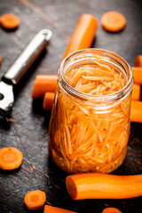 Canned carrots in a glass jar on the table.