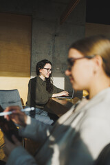 Smiling positive diverse colleagues in casual clothes working on a new project sitting together at the negotiation table during a meeting in a bright creative workspace