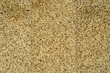 Granite background with fine texture. Cladding slabs of granite with a yellow tint.