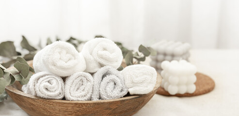 Spa composition with white towels in a wooden plate.