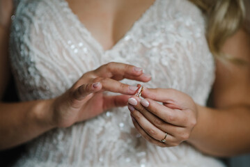 The bride puts a wedding ring on finger. Close up of hands of woman showing elegant diamond ring on the finger, love and wedding concept. Engagement. Soft and selective focus.