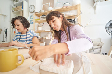 Women making handmade pottery in a pottery class. Handicraft and hobbies concept.