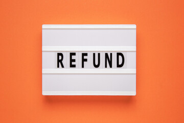 Lightbox with word refund on orange background. Business concept