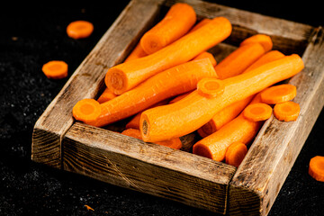 Fresh carrots on a wooden tray. 