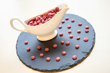 Ruby chocolate flakes in a white ceramic bowl