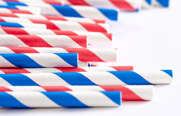 Multi-colored paper straws for drinks close-up on a white background.