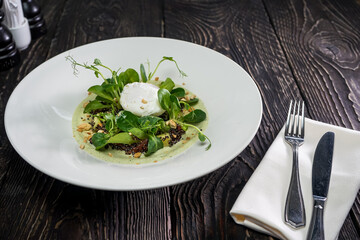 breakfast salad with poached egg in a plate on a dark background
