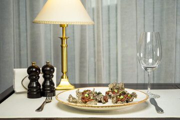 tartar in chips in a plate on the table with an empty glass
