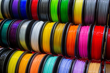 Many multi-colored spools of thread of filament for printing 3d printer. Material coils for printing 3D printer. Spools of 3D printing motley different colors filament. ABS wire plastic for 3d printer