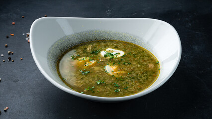 Fresh sorrel soup with meat, potatoes, eggs and herbs.