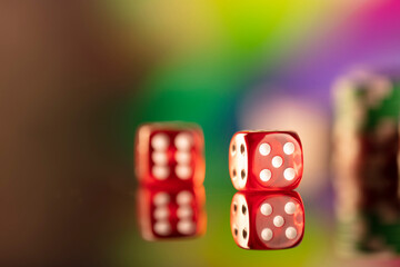 Casino theme.  Gambling games. Dices and poker chips on a colorful bokeh background.