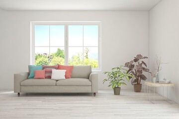 Fototapeta premium White living room with sofa and summer landscape in window. Scandinavian interior design. 3D illustration