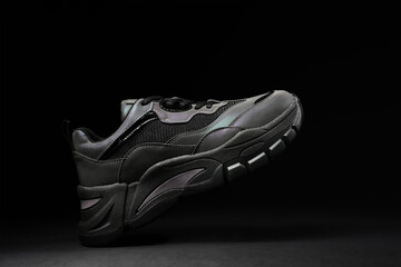 Stylish sneaker on black background. Glowing creative fashion shoe