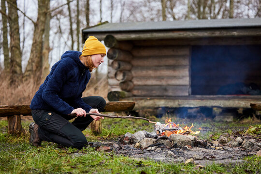 young woman in nature roasting marshmallow