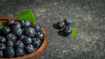 Blueberries on a textured black background, copy space.