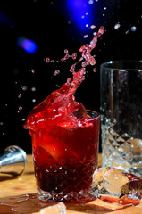 Fototapeta na wymiar red cocktail on bar counter with splashes 