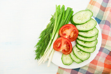 Sliced vegetables on white plate top view
