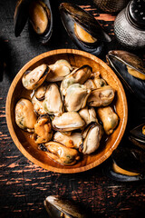 Pickled mussels in a wooden plate on the table. 