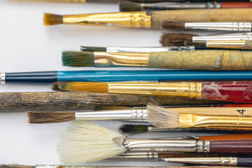 Obraz premium Close-up, old paint brushes on a white background.