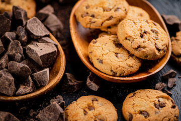 Wooden plate with cookies and pieces of milk chocolate. 