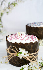 Easter cake decorated with white icing and a sprig of cherry blossoms. Christian traditions. Close-up. Selective focus.