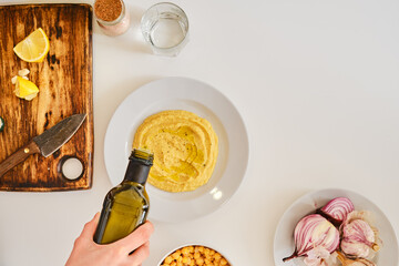 Adding olive oil to hummus, view from above