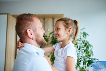 Adorable little girl in white dress hugging loving father