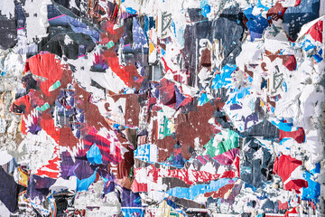 Naklejka premium Torn paper collage background on an old poster on a street wall. Texture and surface of torn paper.