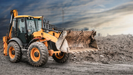 Bulldozer or loader at a construction site shovels mountain soil into a heap. Powerful wheel loader...