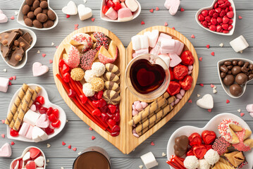 Valentine's Day concept. Top view photo of wooden heart shaped serving tray with confectionery...