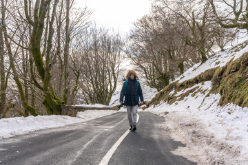 Photographer man walking on a snowy road, enjoying winter photography