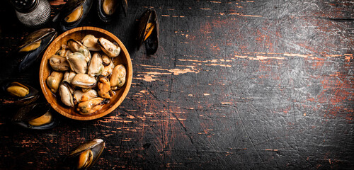 Pickled mussels in a wooden plate on the table. 