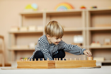 A happy child at kindergarten is playing with educational toys. Montessori method and development...